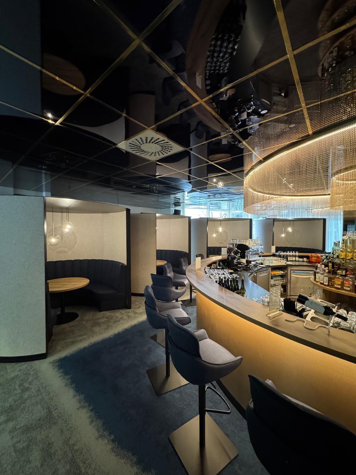 Eine stilvolle Bar mit halbkreisförmigen Sitznischen und elegant beleuchtetem Tresen