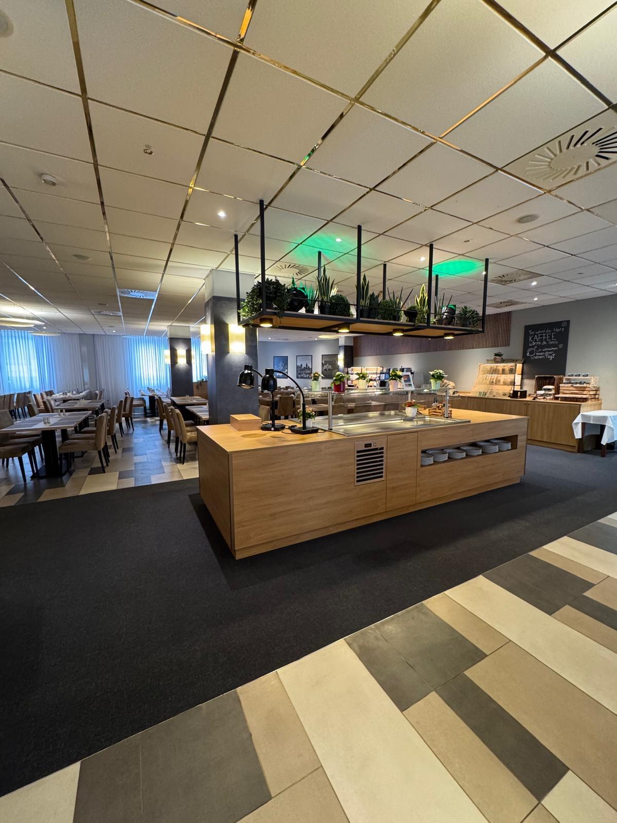 Modern Frühstücksbuffet mit Holzmöbeln, grünen Pflanzen und ruhigem Ambiente